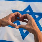 Hand in heart shape on Israel flag